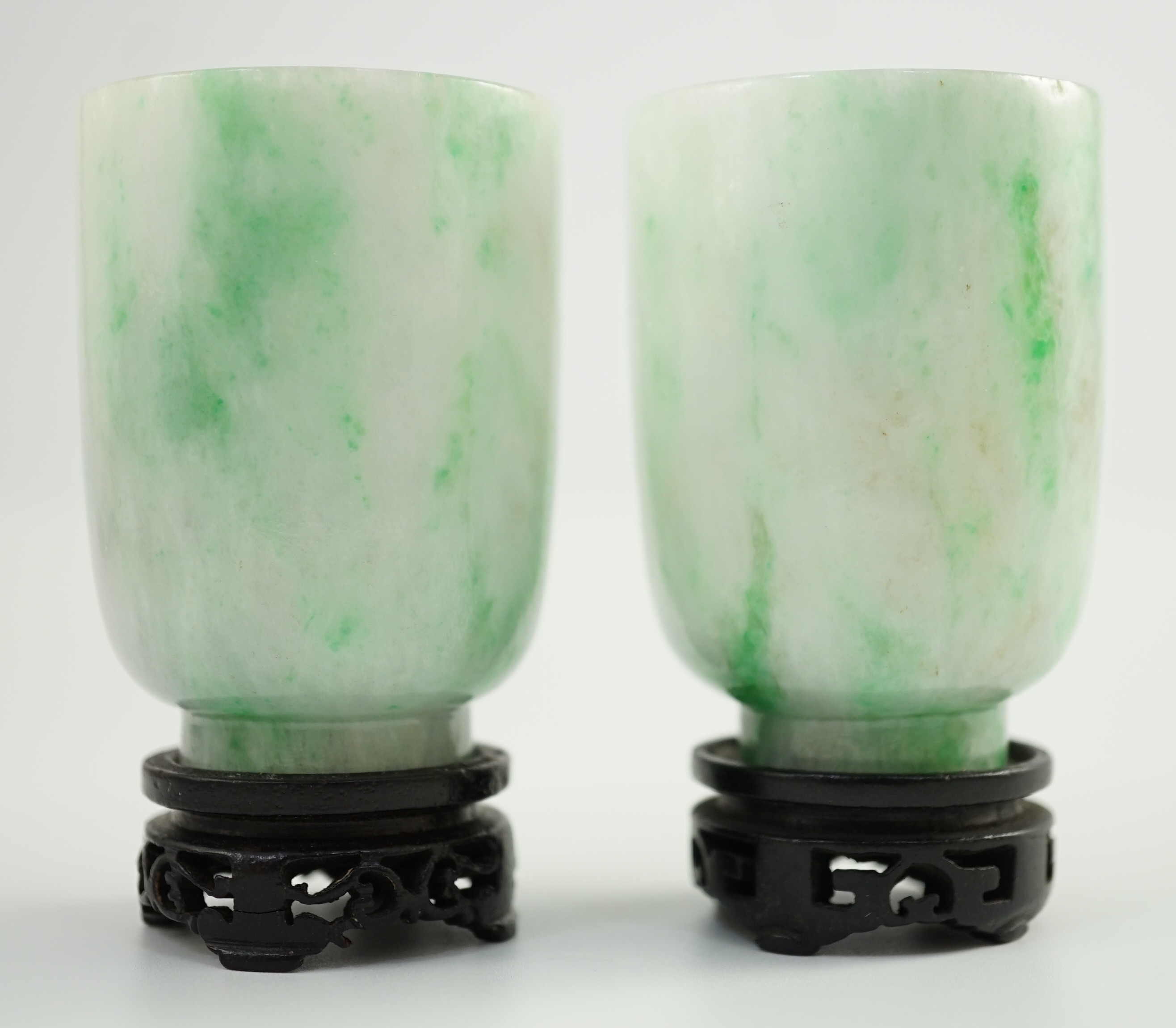 A pair of Chinese jadeite cups, 6.2cm high, wood stands, fitted box